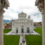 people near Piazza dei Miracoli in Italy under white and blue sky